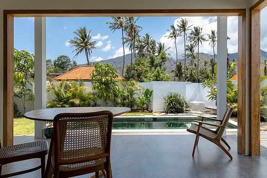 Tropical pavilion looking through to pool, palms, distant mountain